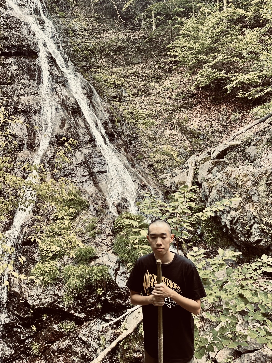 Sumiaki Kusahata standing in front of a waterfall
